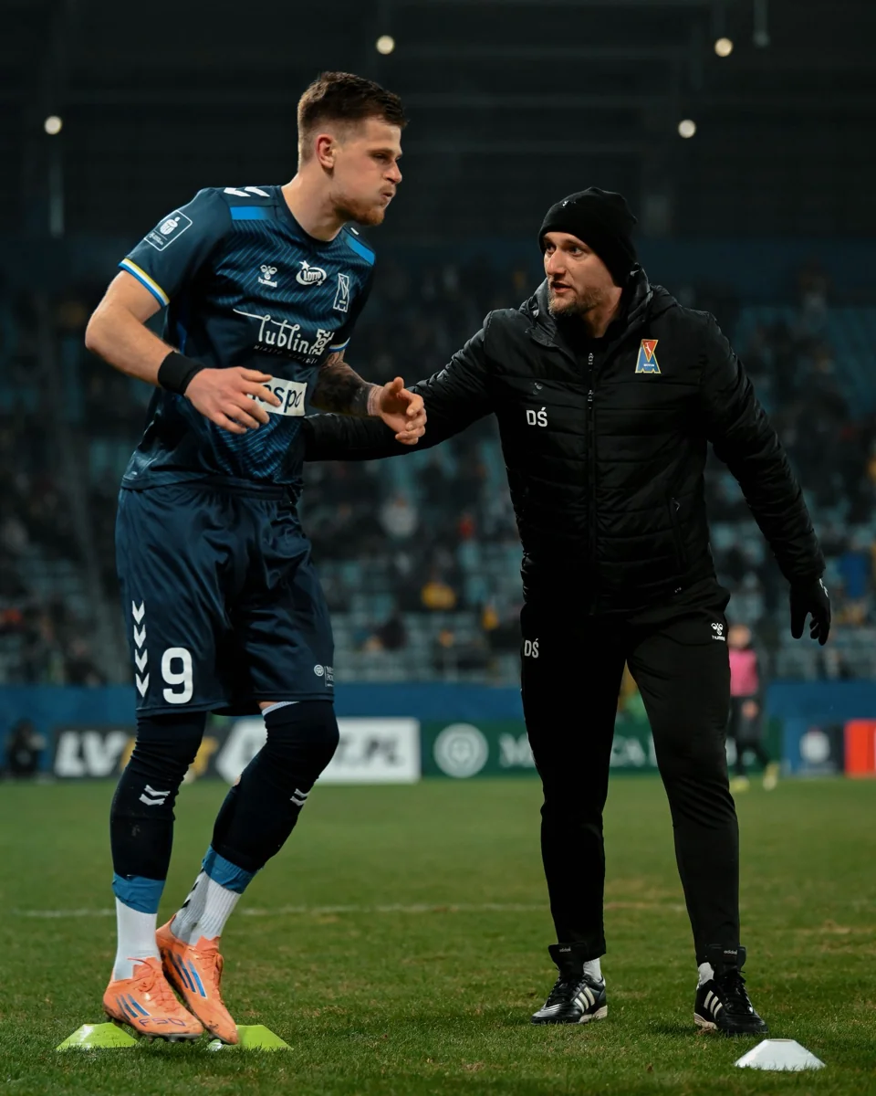 Damian i zawodnik podczas pracy przy linii boiska